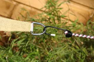 Die Haken von den Spanngurten eingehängt in die starken Edelstahlringe vom Sonnenschutzsegel konkav