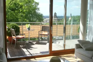 Terrassenansicht mit Sitzecke geschützt durch eine Balkonverkleidung -Farbe sisal.