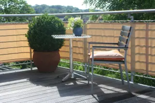 Terrassenansicht mit Sitzecke geschützt durch eine Balkonverkleidung -Farbe sisal.