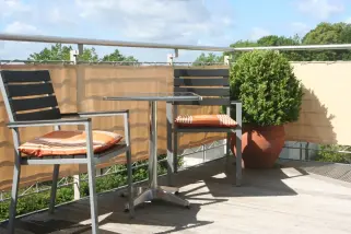 Terrassenansicht mit Sitzecke geschützt durch eine Balkonverkleidung -Farbe sisal.