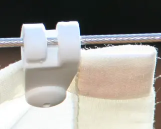 Laufhaken eingehängt in Edelstahlseil führt das Sonnensegel 